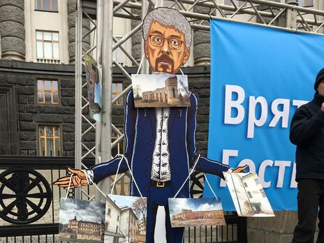Фігуру Ткаченка обвішали фотографіями занедбаних Мінкультом об'єктів. Активісти під Кабміном вимагали віддати Гостинний двір громаді Києва