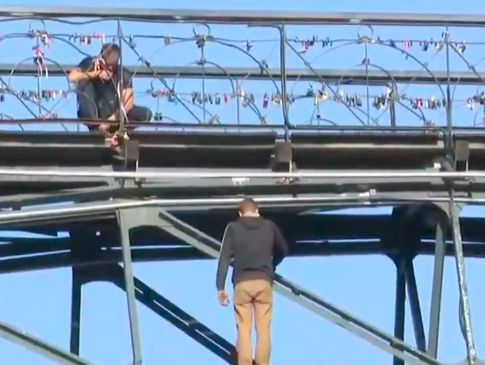 На Мосту влюбленных в Киеве мужчина угрожает покончить жизнь самоубийством