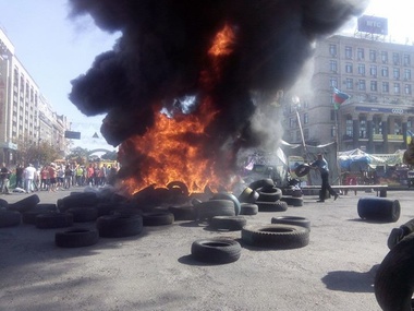 Коммунальщики начали убирать баррикады на Майдане, активисты подожгли шины