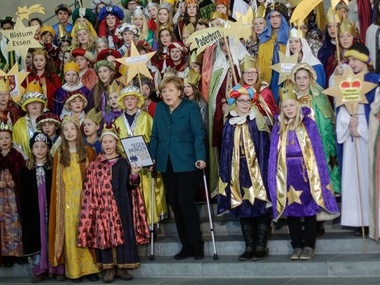 Меркель, опираясь на костыли, впервые после травмы появилась на публике
