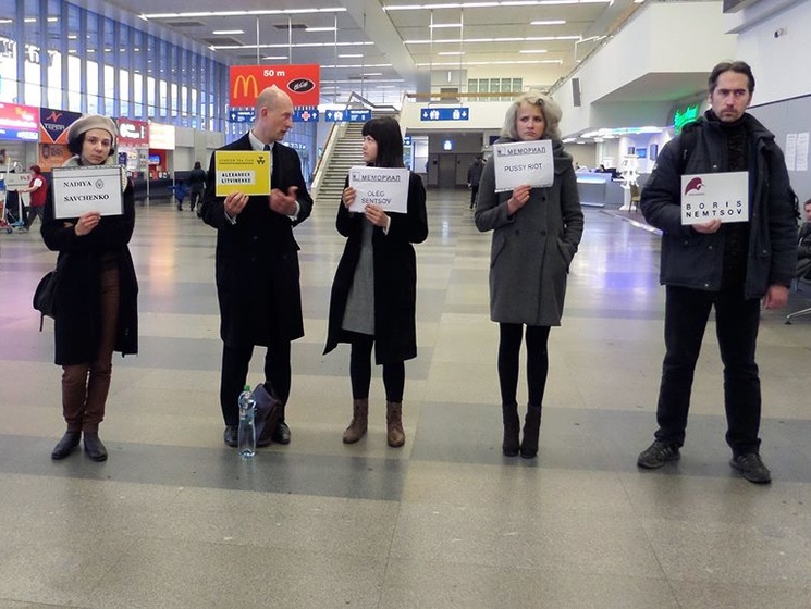 В аэропортах США активисты встречают россиян с табличками, на которых написаны имена убитых и политзаключенных