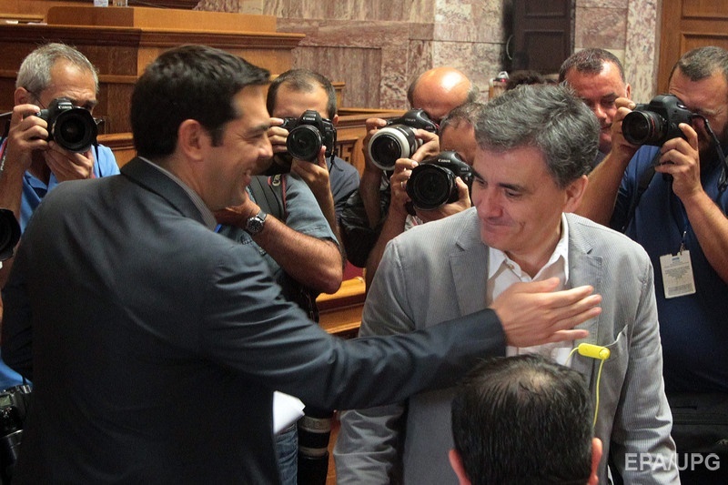 Премьер-министр Греции Алексис Ципрас приветствует нового министра финансов Евклида Цакалотоса в парламенте Греции 10 июля. Предыдущий глава Минфина страны 