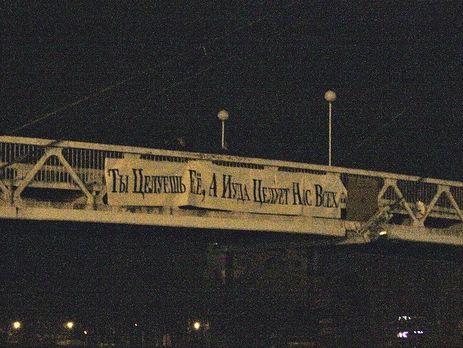 В ночь с 13 на 14 февраля православные активисты закрепили на Мосту поцелуев баннер с надписью "Ты целуешь ее, а Иуда целует нас всех"