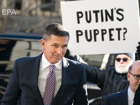 Флинн у здания суда в Вашингтоне в 2018 году; надпись на плакате: "Путинская марионетка"