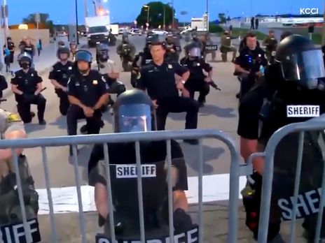 В разных городах США полицейские становятся на колено в поддержку протестующих. Видео 