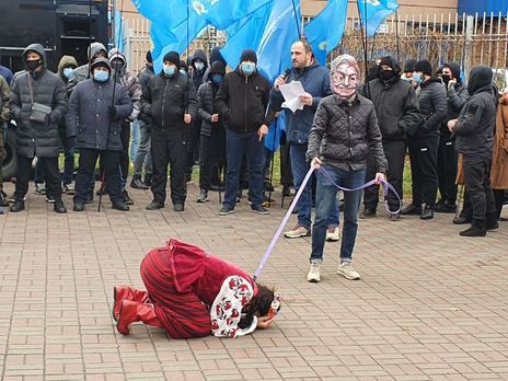 У посольства США мужчина в маске Сороса набрасывал ошейник на девушку в национальном украинском костюме и водил ее по кругу