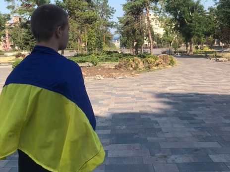 В оккупированном Мариуполе подросток вышел на площадь возле разрушенного драмтеатра с флагом Украины