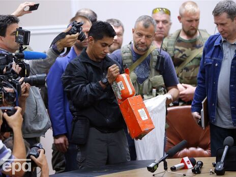 Малайзийский эксперт в присутствии боевиков "ДНР" и журналистов в Донецке осматривает черный ящик сбитого Boeing 777 21 июля 2014 года