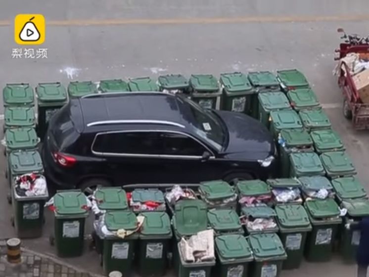 В Китае дворник заблокировал неправильно припаркованное авто 40 мусорными баками. Видео