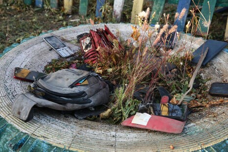 В селе Гроза на клумбе спасатели выложили подобранные на месте трагедии телефоны. Разбитые, обгоревшие. В основном все старенькие, кнопочные. На один из них все кто-то звонит и звонит