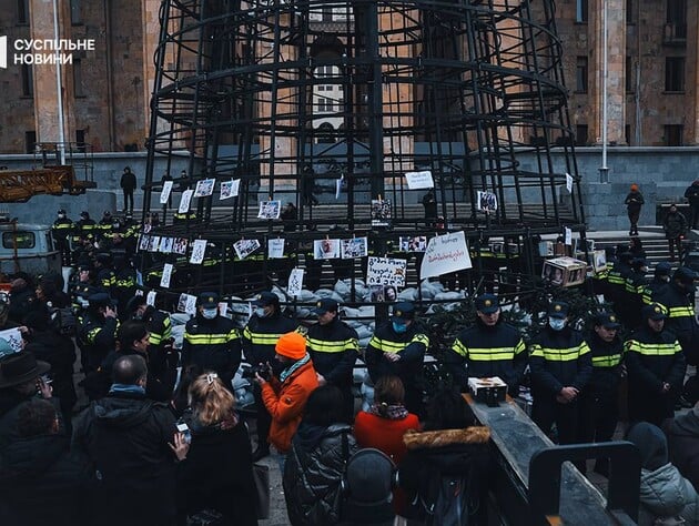 В Тбилиси начали охранять новогоднюю елку. Активисты развесили на ней фото избитых журналистов и митингующих