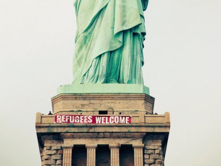 В США на пьедестале статуи Свободы вывесили баннер в поддержку беженцев