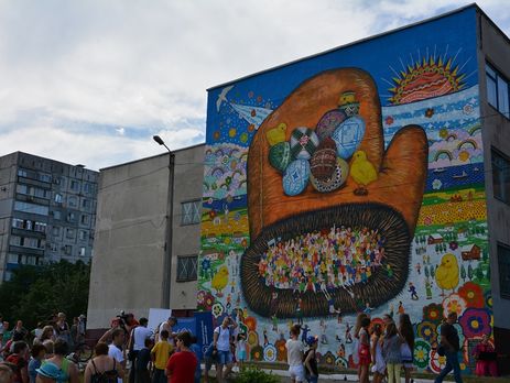 В Мариуполе японский художник нарисовал гигантскую рукавичку на стене школы, пострадавшей от обстрела. Фоторепортаж