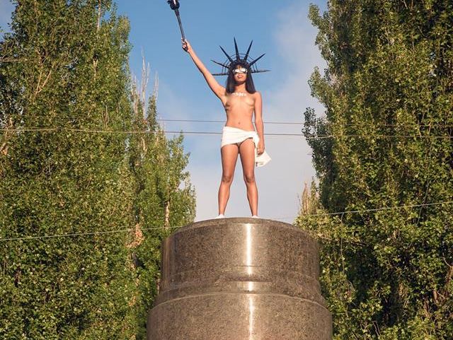 ﻿"Шоколадна свобода". У Києві активістка Femen залізла на постамент і кидалася цукерками Roshen