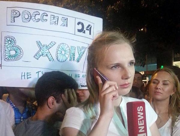 В Армении за спиной журналистки LifeNews митингующие подняли плакат "Россия 24", в жопу"