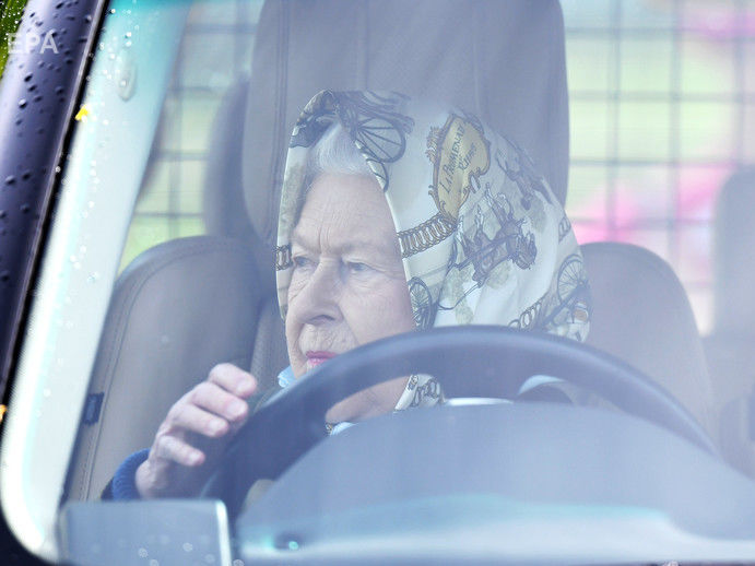 ﻿Британська королева Єлизавета II приїхала на автомобілі на кінні скачки. Фоторепортаж