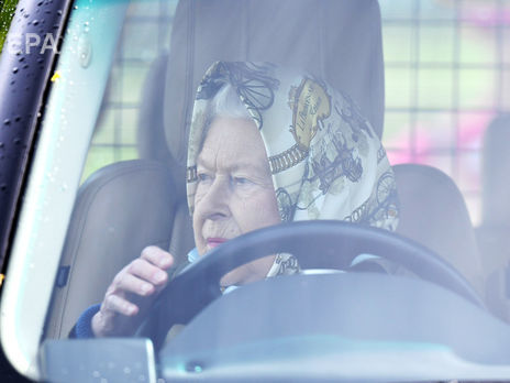 ﻿Британська королева Єлизавета II приїхала на автомобілі на кінні скачки. Фоторепортаж