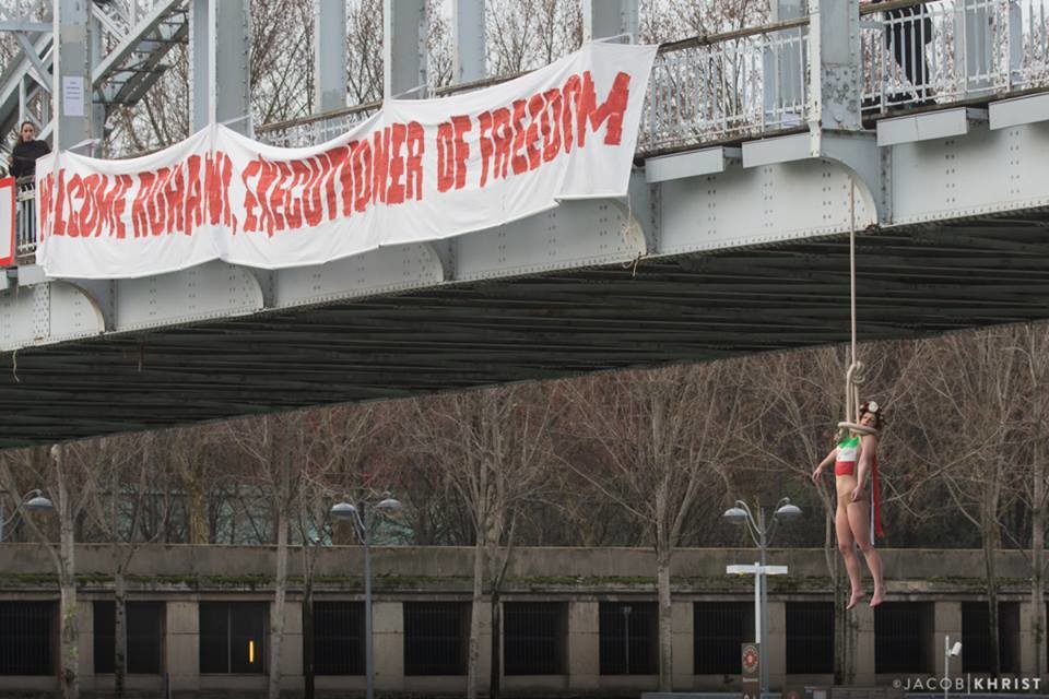 Активистка Femen повисла под парижским мостом в знак протеста против приезда Рухани. Фоторепортаж / Гордон